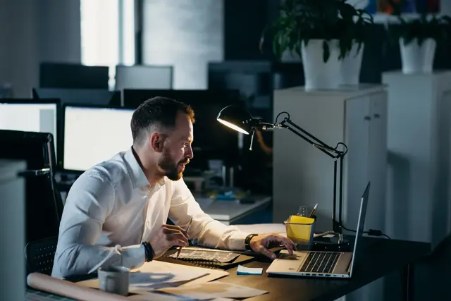 Man Has Overwork And Sitting With Laptop And Table Lamp